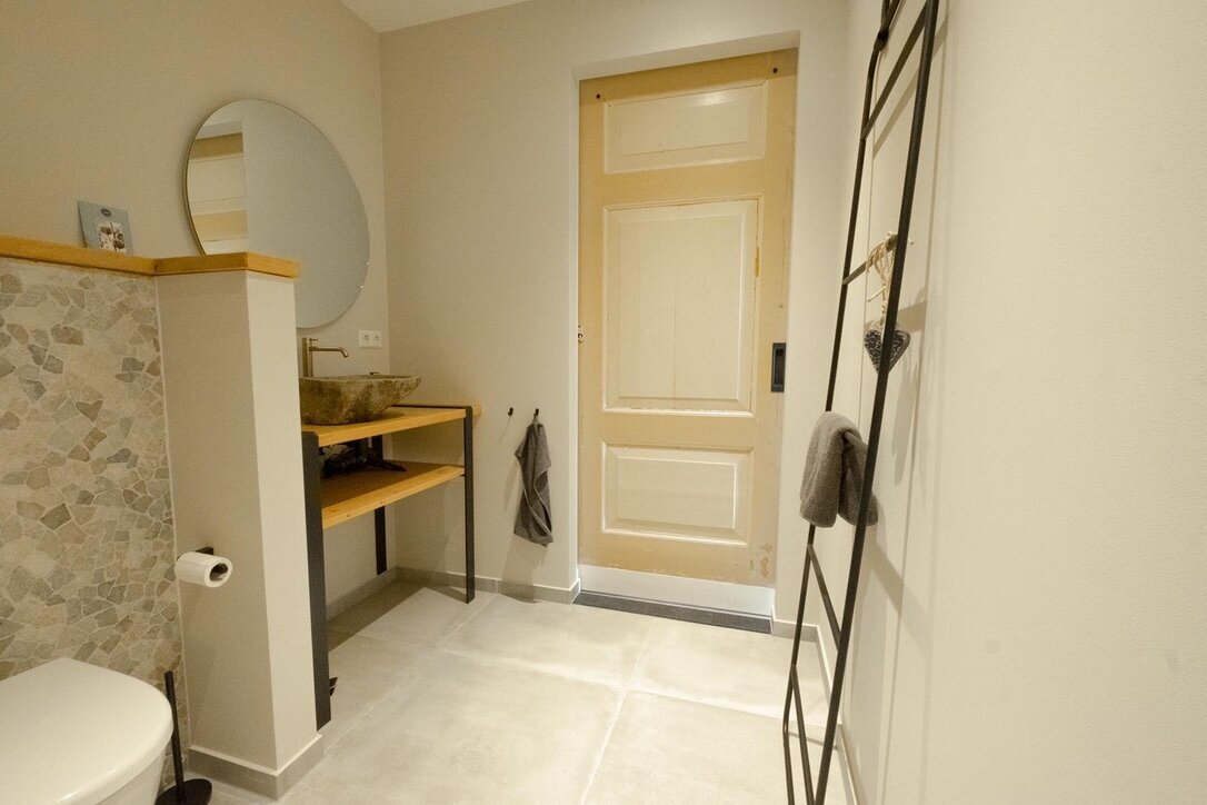 Toiletruimte met wastafel en een naadloos afgewerkte wand