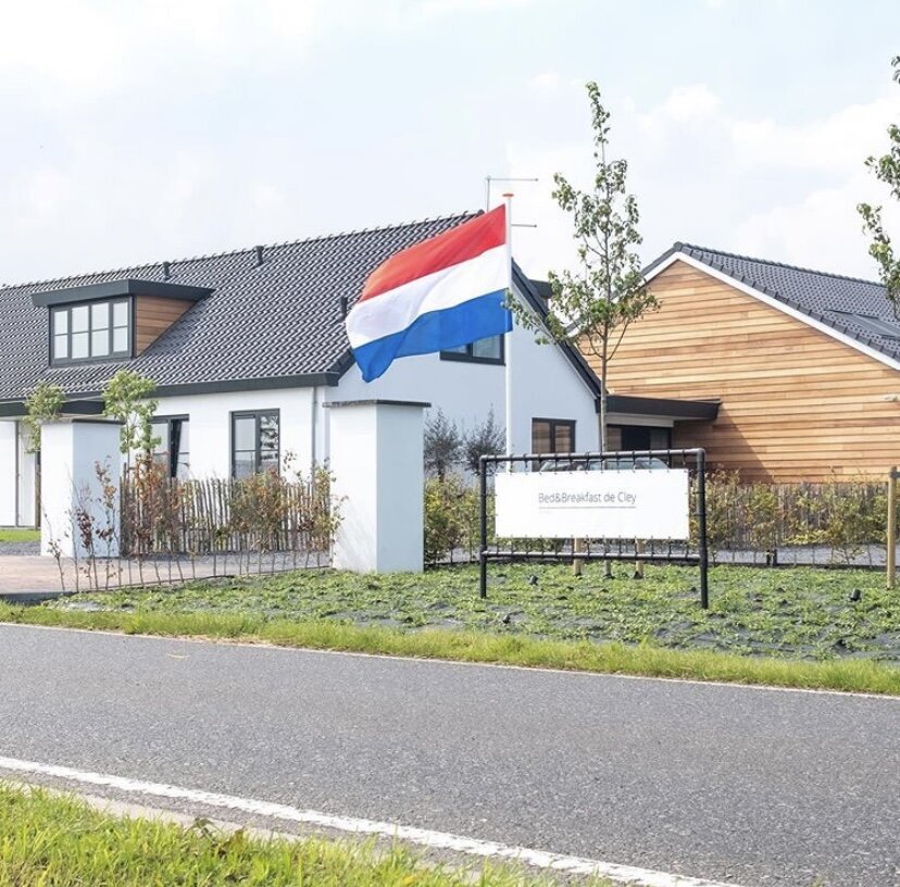 Het pand van De Cley van buiten, met de vlag uit bij de oplevering